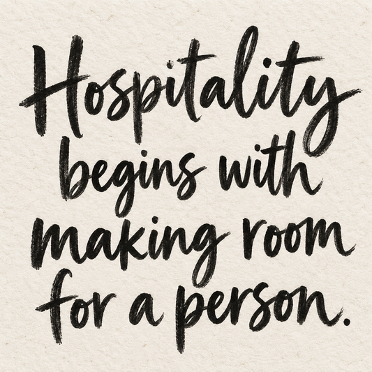 Black brush lettering on ivory handmade paper: “Hospitality begins with making room for a person.”