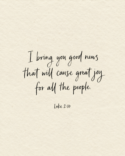 I bring you good news that will cause great joy for all the people. Luke 2:10, handwritten in black ink on ivory paper.