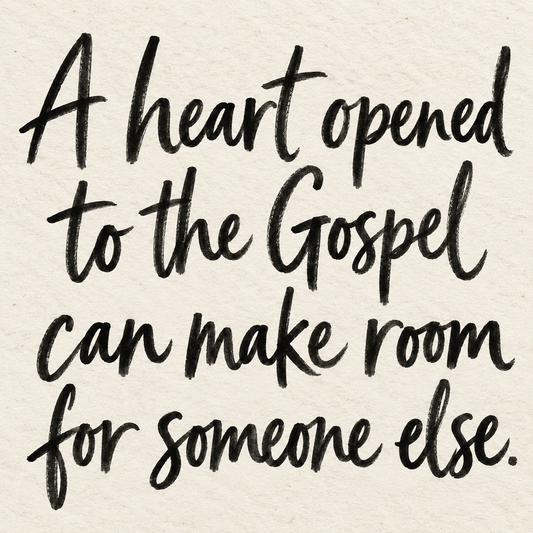 Black brush lettering on ivory handmade paper: “A heart opened to the Gospel can make room for someone else.”