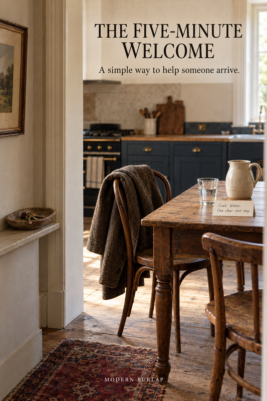 A lived-in kitchen threshold with a guest coat, water pitcher and two chairs. Headline: The Five-Minute Welcome.