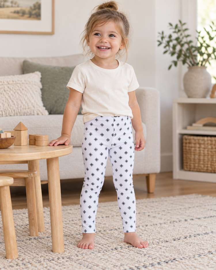 AI-styled lifestyle view of Baby + Kids Organic Leggings | Signature Prints in Black on White Snowflakes