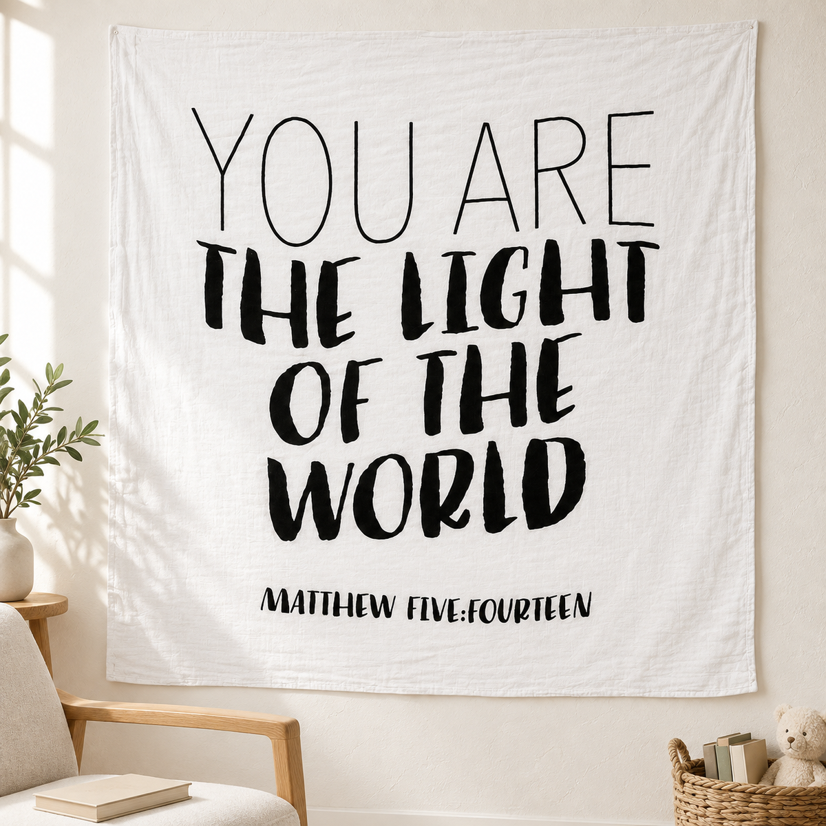 Matthew 5:14 Scripture swaddle displayed as wall art beside a nursery chair.
