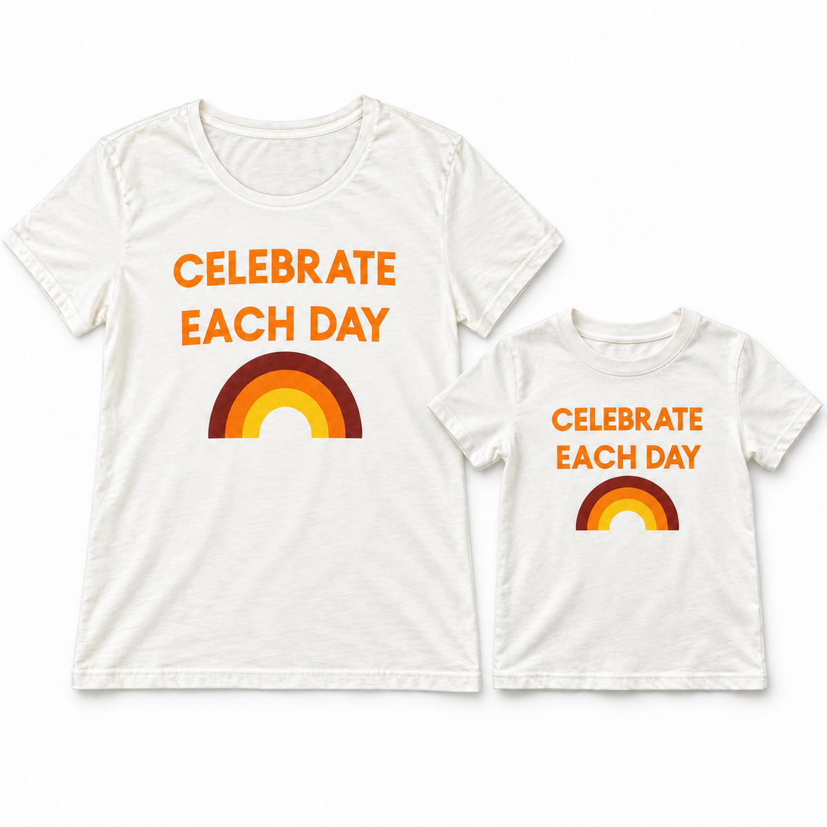 Celebrate Each Day matching women's and kids' tees shown together in a studio flat lay; each tee sold separately.