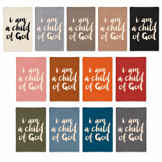 I Am a Child of God knit throw in all thirteen color options, arranged in an even studio flat lay. Each color sold separately.