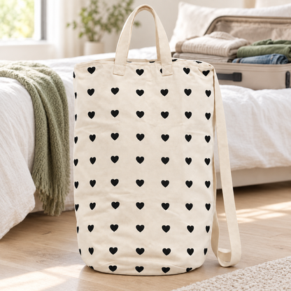 Hearts canvas laundry bag beside a packed suitcase; styling accessories not included