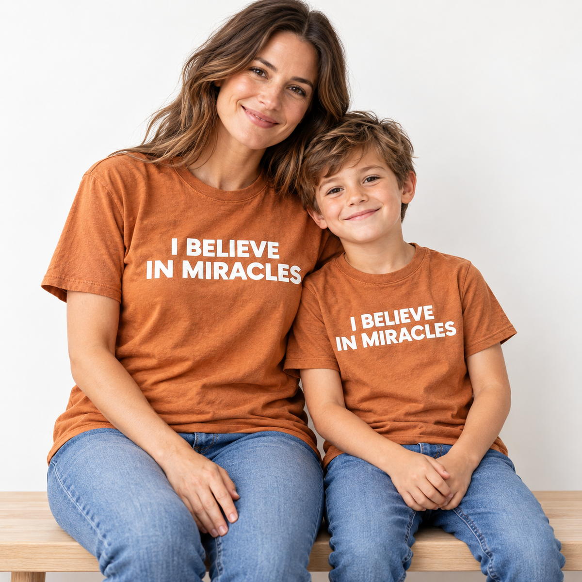 I Believe in Miracles mama-mini Sunburn short-sleeve tee — AI-styled studio image; each tee sold separately.