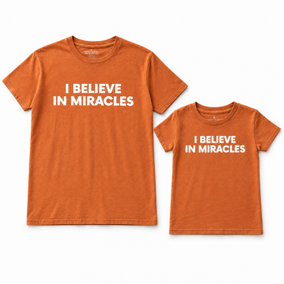 I Believe in Miracles adult and kids' tees together in a studio flat lay; each tee sold separately.