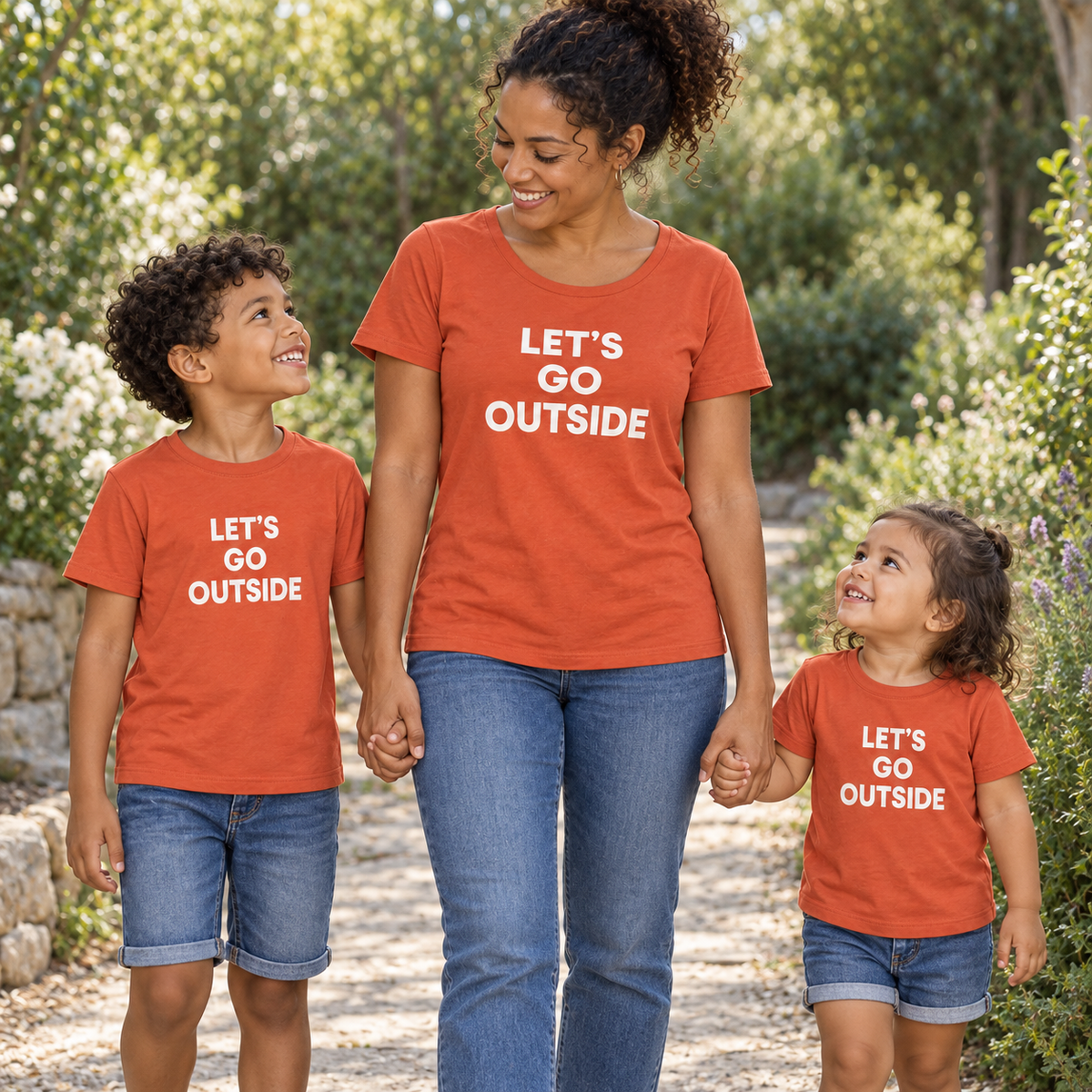 AI-styled family wearing matching Let's Go Outside women's and kids tees; each tee sold separately