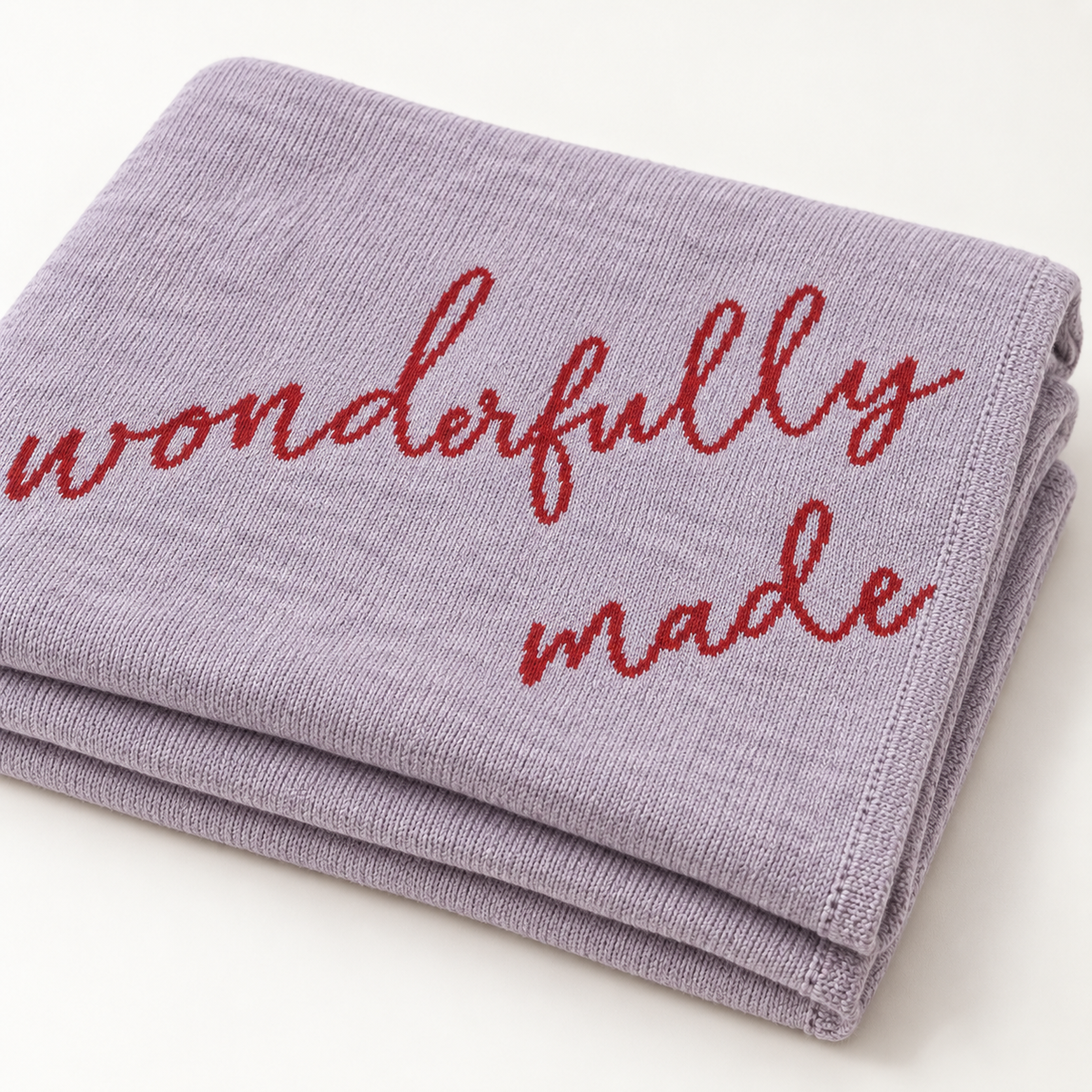 Folded Lipstick Fearfully and Wonderfully Made recycled cotton blanket showing red script, knit texture and neatly finished edges.