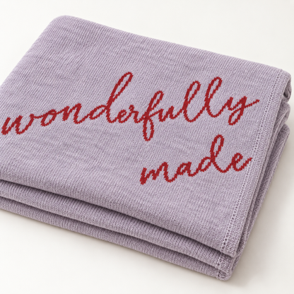 Folded Lipstick Fearfully and Wonderfully Made recycled cotton blanket showing red script, knit texture and neatly finished edges.