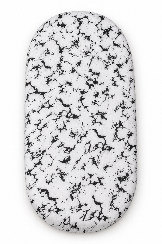 Marble organic bassinet and small changing pad sheet shown fitted on a pad against white.