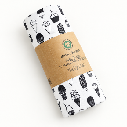 Mini Ice Cream Love organic muslin swaddle rolled in its original kraft packaging.