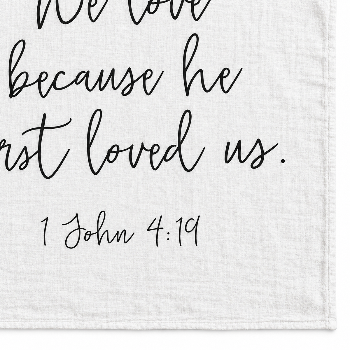 1 John 4:19 Scripture swaddle detail showing the printed lettering and hem.