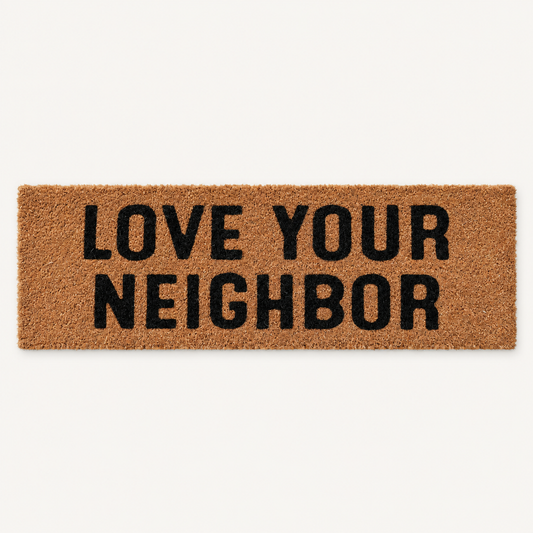 Love Your Neighbor | XL Christian Doormat shown alone on a warm off-white studio background.