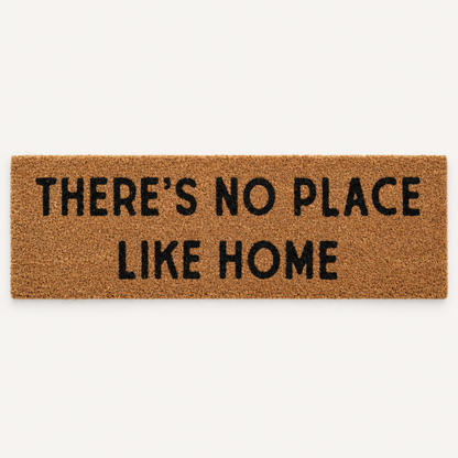 There's No Place Like Home | XL Doormat shown alone on a warm off-white studio background.
