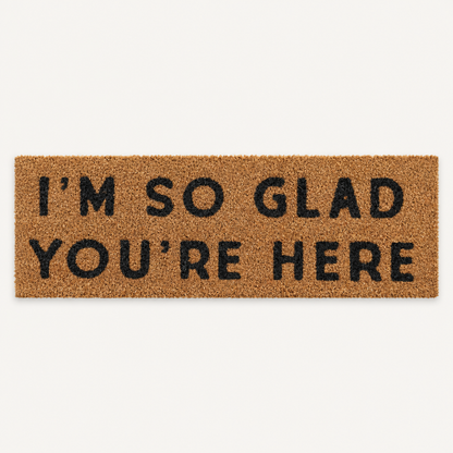 I'm So Glad You're Here | XL Doormat shown alone on a warm off-white studio background.