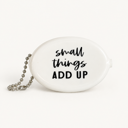 White coin pouch with Small Things Add Up message, front view