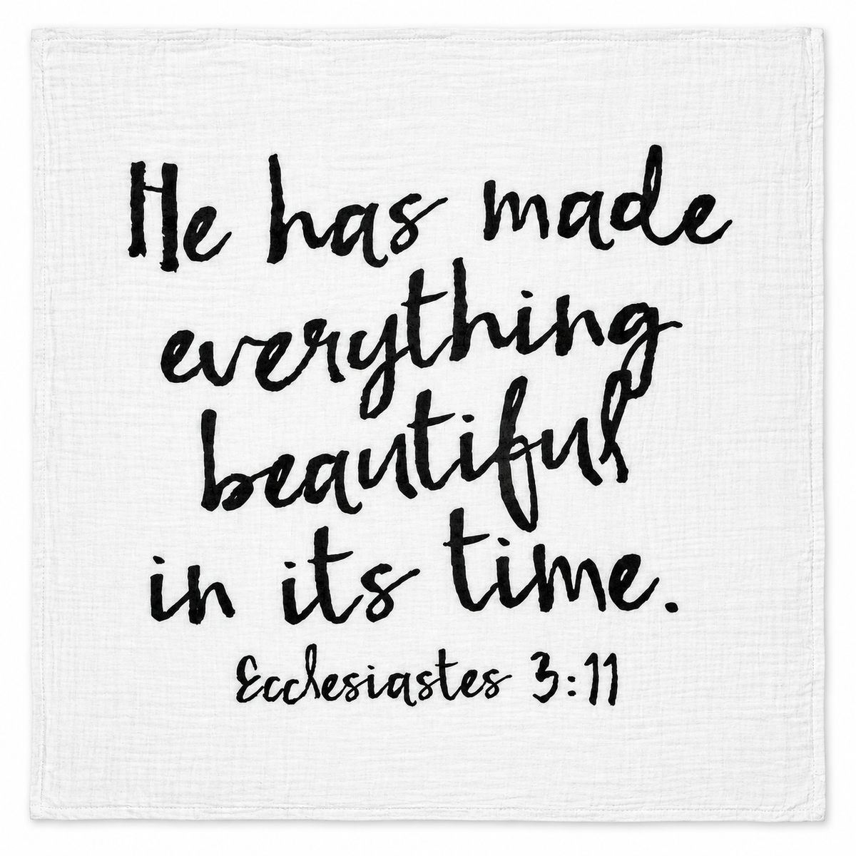 Ecclesiastes 3:11 organic cotton muslin swaddle, full black lettering design on white fabric, studio view.