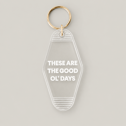 These Are the Good Ol’ Days clear vintage keychain with white lettering and a gold split ring, front studio view.