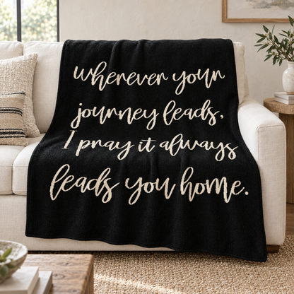 Black Wherever Your Journey knit throw draped over an ivory sofa.