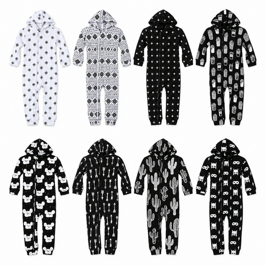 All eight signature-print organic hooded zip coveralls arranged at equal scale on white: Snowflakes, Nordic Winter, Swiss Cross, Coffee Love, Modern Mouse, Arrows, Cactus and Hero Struck.