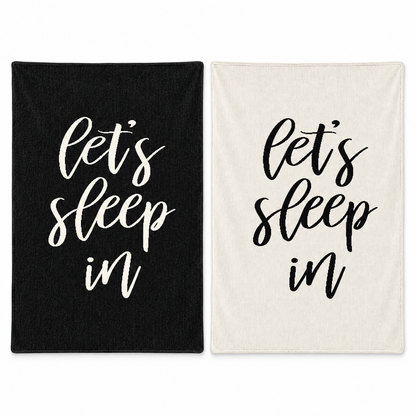 Let's Sleep In blankets in Black and Natural, shown together on white.