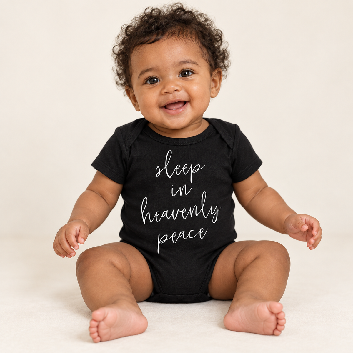 Baby wearing the black Sleep in Heavenly Peace short sleeve bodysuit