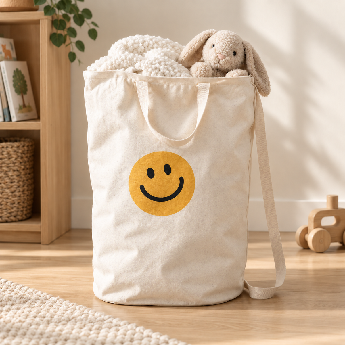 Smiley Face canvas bag holding a blanket and soft toy in a bright playroom.