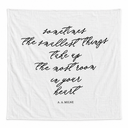 Sometimes the Smallest Things organic muslin swaddle laid flat on white, showing the complete black script design.