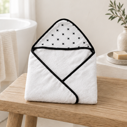 Swiss Cross Muslin + Terry Hooded Baby Towel — folded towel styled on a wooden bathroom bench