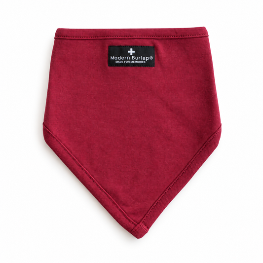 Maroon organic cotton bibdana with a pointed front and small black Modern Burlap label on white.