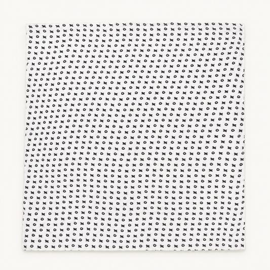 XO organic muslin swaddle laid flat, showing its complete black and white print.