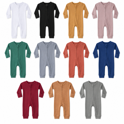 All eleven solid colors of organic thermal baby zip coveralls in a studio flat lay.