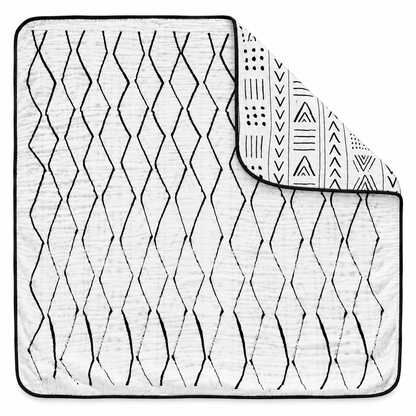 Mud Cloth + Moroccan Reversible Muslin Quilt — one quilt with a folded corner showing both reversible prints.