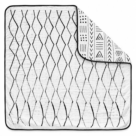 Mud Cloth + Moroccan Reversible Muslin Quilt — one quilt with a folded corner showing both reversible prints.