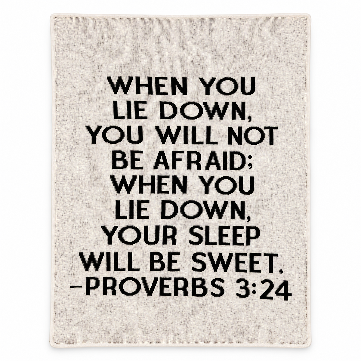 Natural ivory Proverbs 3:24 recycled cotton blanket with black block lettering, shown flat with smooth finished edges on white.