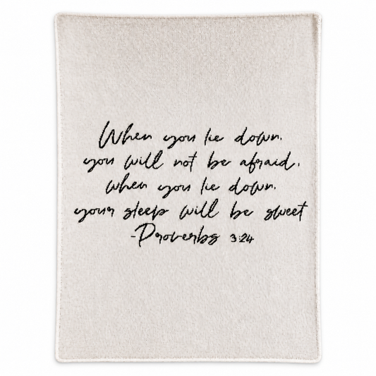 Proverbs 3:24 Natural Script recycled cotton blanket, black handwritten lettering on natural ivory, full studio view.