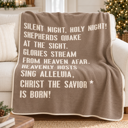 Taupe Silent Night recycled cotton throw styled on an ivory sofa in a softly decorated Christmas living room.