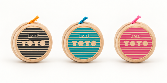 Black, teal, and pink Sling-Slang wooden yo-yos shown full-size together