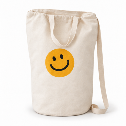 Smiley Face ivory cotton canvas bag with yellow smile, carrying handles and shoulder strap on white