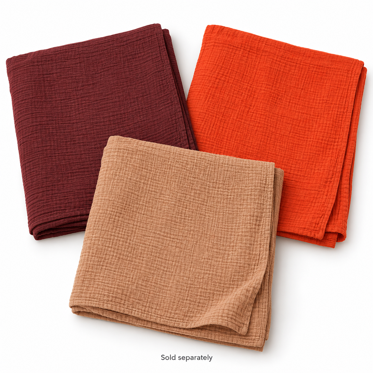 Maroon, Wildfire orange and Ginger organic cotton muslin swaddles on white; sold separately.