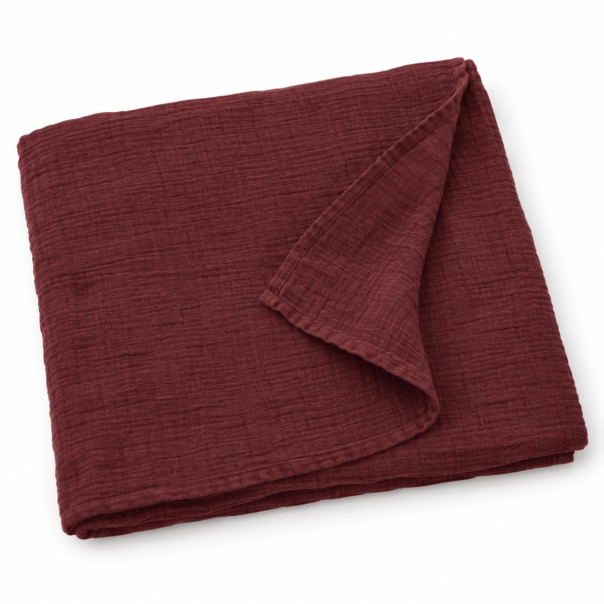 Maroon organic cotton muslin swaddle folded on white, with a turned corner showing the fine weave and hem.