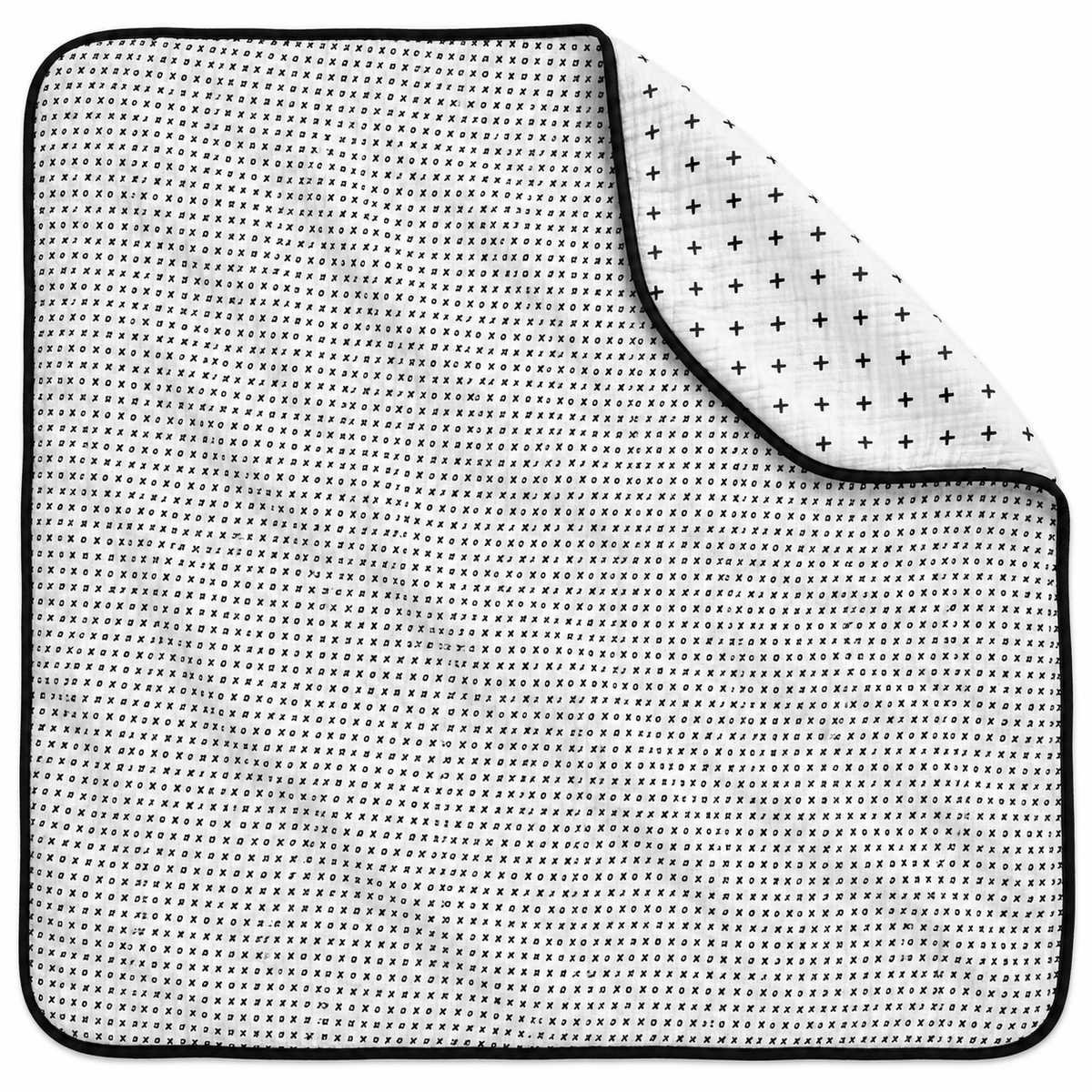 Swiss Cross + XO Reversible Muslin Quilt — one quilt with a folded corner showing both reversible prints.