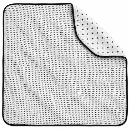 Swiss Cross + XO Reversible Muslin Quilt — one quilt with a folded corner showing both reversible prints.