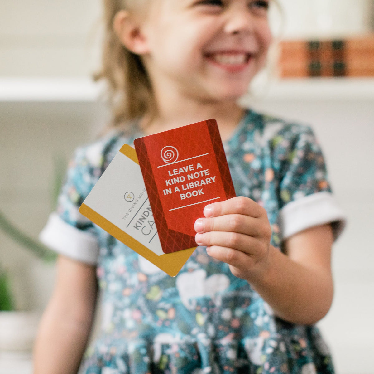 Child holding a Kindness Card