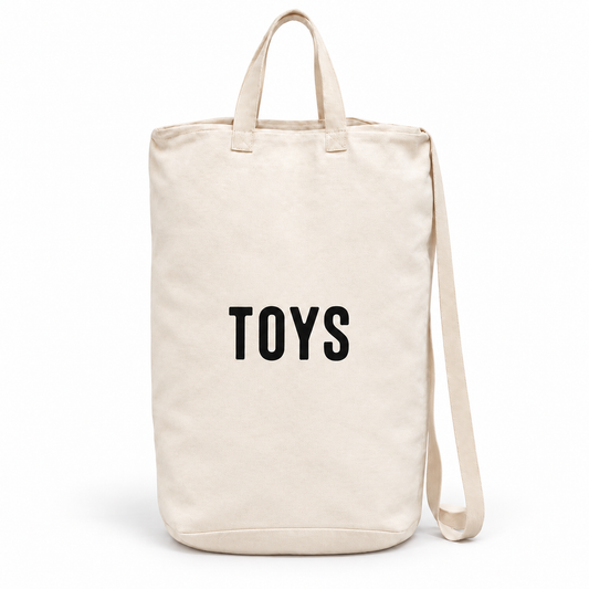 Toys ivory cotton canvas bag with black lettering, handles and shoulder strap on white