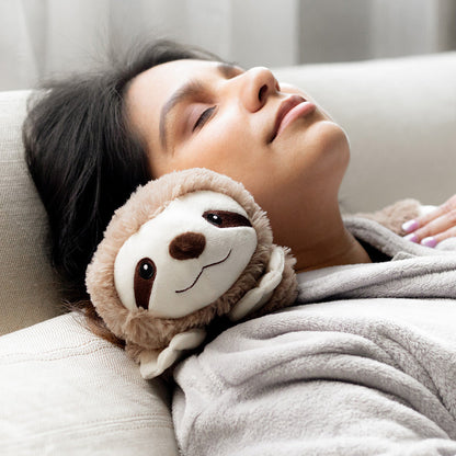 Woman resting on a sofa with the Sloth Warmies wrap around her shoulders