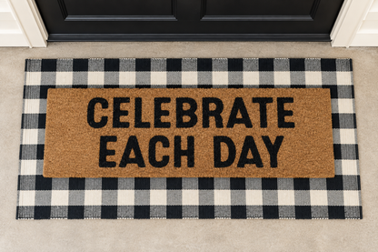 XL Doormat | Celebrate Each Day layered over a black and ivory buffalo plaid runner at a black door.