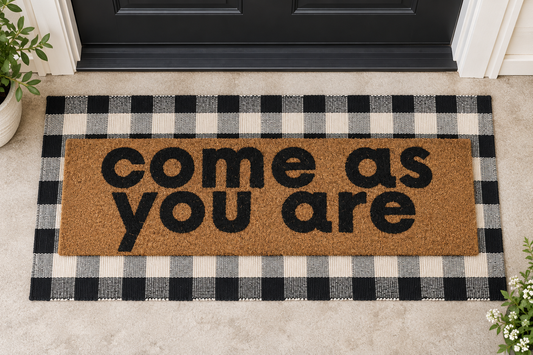 XL Doormat | Come As You Are layered over a black and ivory buffalo plaid runner at a black door.
