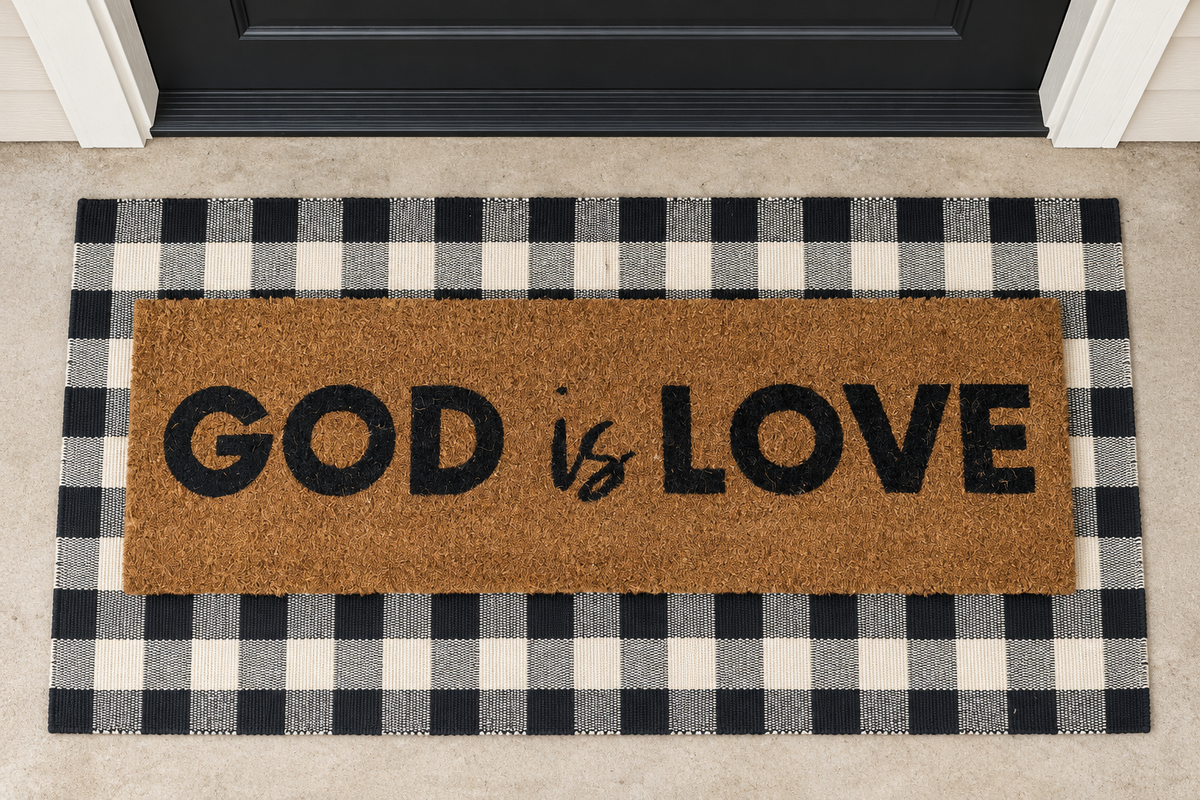 XL Christian Doormat | God Is Love layered over a black and ivory buffalo plaid runner at a black door.